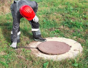 worker performing septic inspection